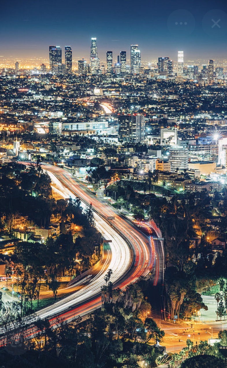 Los Angeles skyline at night with freeway light trails