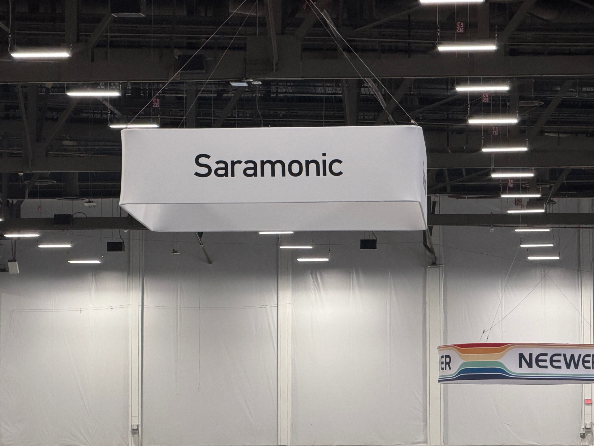 Saramonic overhead banner at NAB Show convention hall with Neewer signage