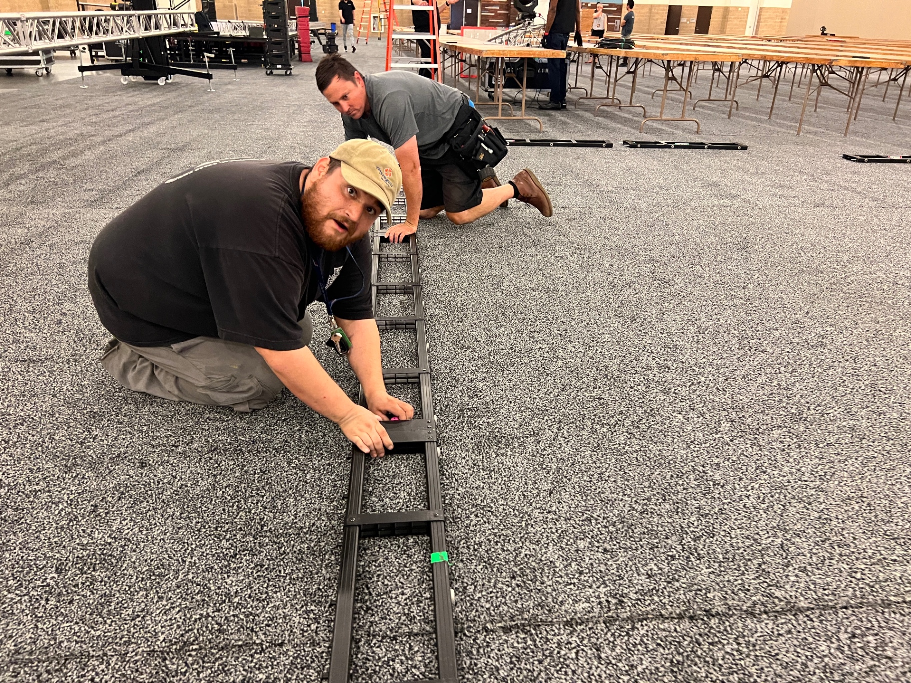 365 Pro Events crew laying cable ramp and stage deck during convention center load-in