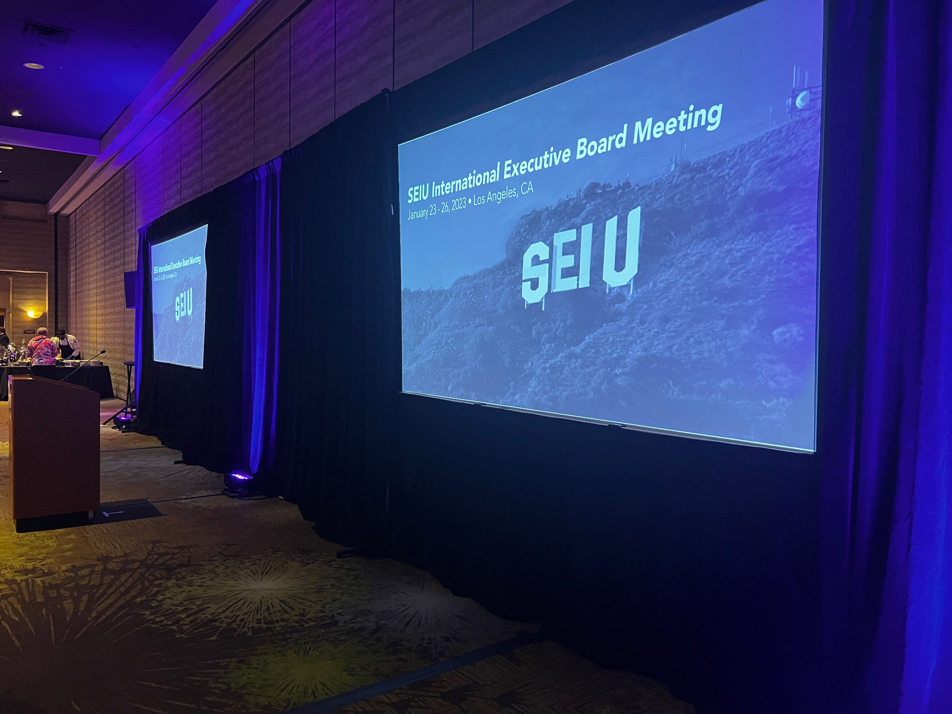 SEIU International Executive Board Meeting stage with dual projection screens showing Hollywood-style SEIU sign